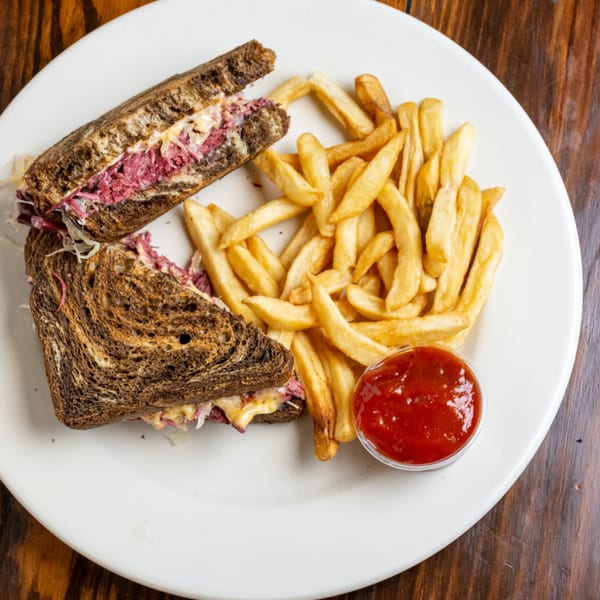 O'Donovan's Irish Pub's Reuben sandwich on dark rye with fries and ketchup on a white plate.