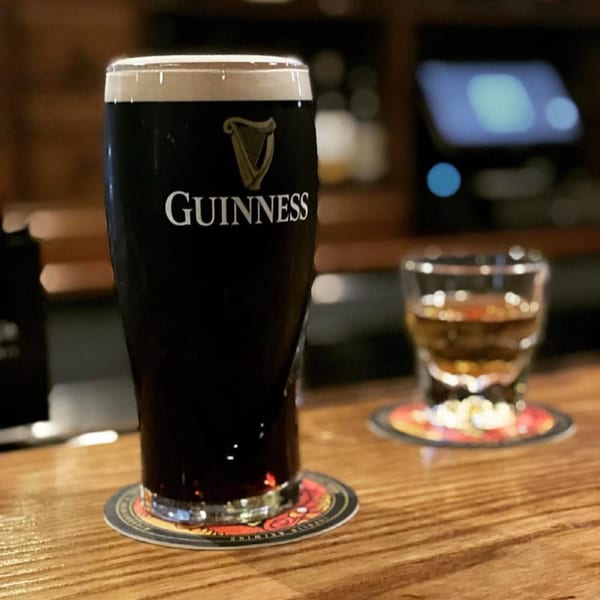 A pint of Guinness and a shot of whiskey on a wooden bar at O'Donovan's Irish Pub.