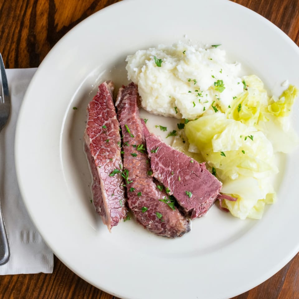 O'Donovan's Irish Pub's corned beef and cabbage with mashed potatoes on a white plate.